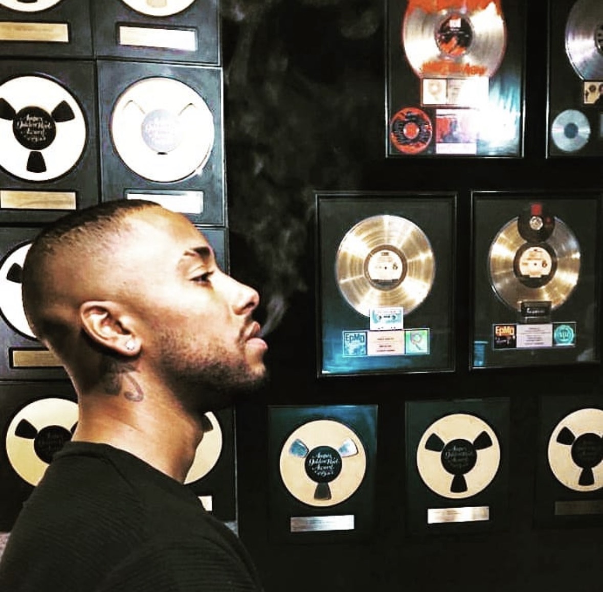 Arik Divine — before a wall of gold records